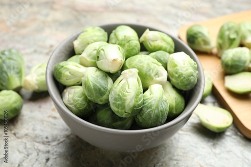 Fresh green Brussels sprouts in bowl on grey table, closeup