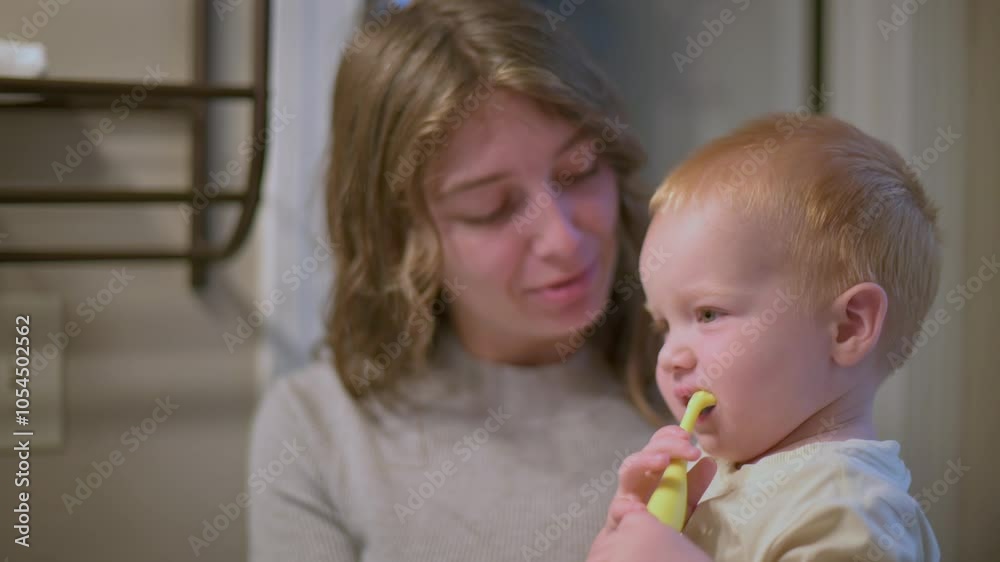 mother smiles at her laughing toddler brushing teeth, fun and affectionate moment during toddler brushing teeth, their morning hygiene routine in the bathroom. toddler brushing teeth mother smiles at her laughing toddler brushing teeth, fun and affectionate moment during toddler brushing teeth, their morning hygiene routine in the bathroom. toddler brushing teeth