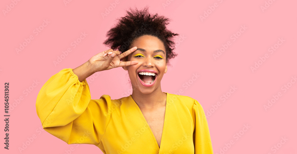 Positive Emotions. Portrait of playful black woman showing peace, victory or two sign, pink studio wall, copyspace Positive Emotions. Portrait of playful black woman showing peace, victory or two sign, pink studio wall, copyspace