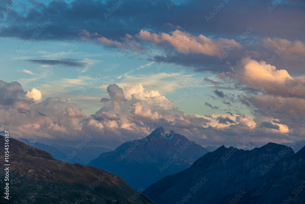 Obraz premium Sunset burning red and orange sky above the snow summits and rocky peaks of the Alps. Beautiful mountain sunset and sunrise in Chamonix valley on the ascent to Montblanc