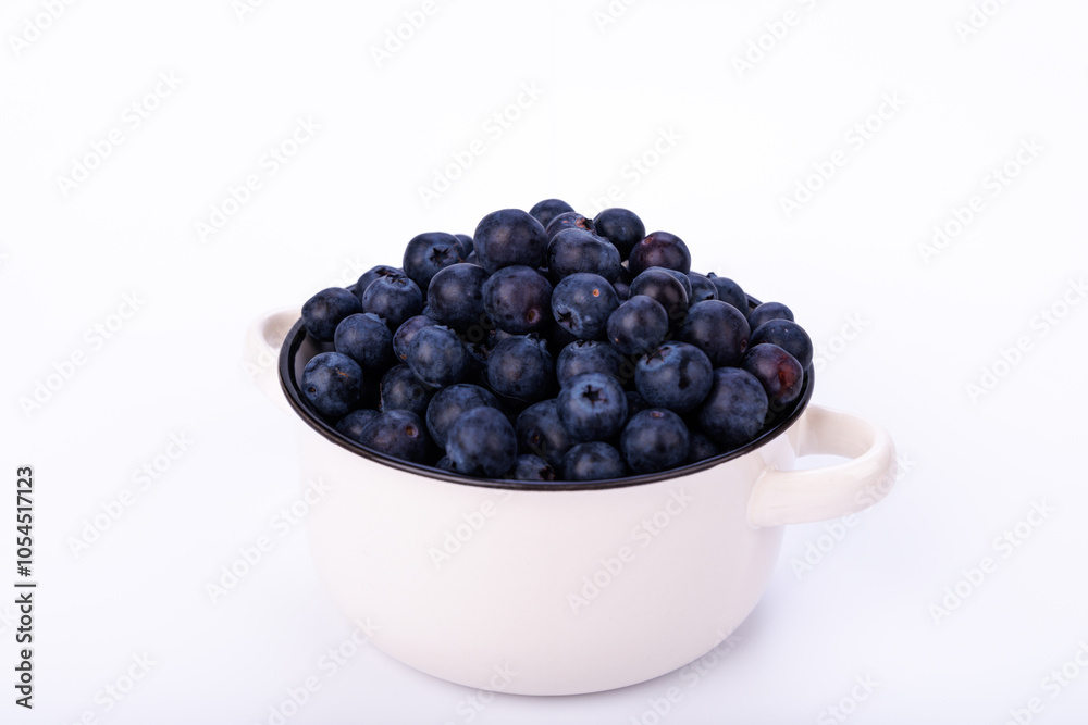 Small ceramic pot filled with fresh blueberries on a clean white background, showcasing the fruit in a simple and minimalist stock photo Small ceramic pot filled with fresh blueberries on a clean white background, showcasing the fruit in a simple and minimalist stock photo