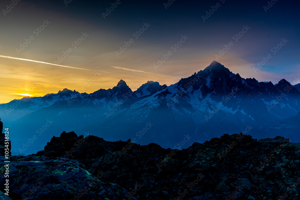 Sunset burning red and orange sky above the snow summits and rocky peaks of the Alps. Beautiful mountain sunset and sunrise in Chamonix valley on the ascent to Montblanc Sunset burning red and orange sky above the snow summits and rocky peaks of the Alps. Beautiful mountain sunset and sunrise in Chamonix valley on the ascent to Montblanc