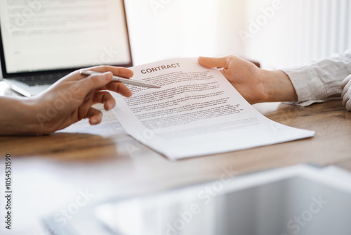 Businesswoman lawyer pointing into contract special points admitting something for colleague or client at the wooden desk in office. Business people teamwork and partnership, meeting concept