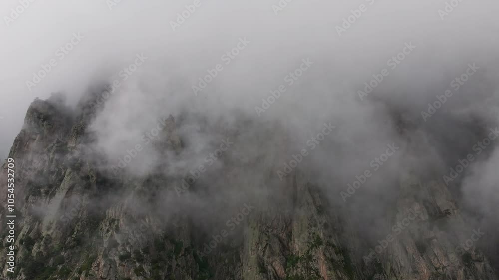 Thick fog moving quickly over mountain peak Thick fog moving quickly over mountain peak