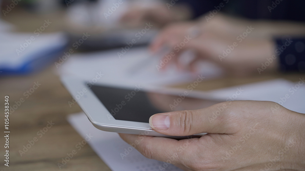 Accountants or auditors reviewing financial documents while sitting at the wooden desk in office. Professionals analyzing paper reports and using calculators, close up. Audit and taxes concept Accountants or auditors reviewing financial documents while sitting at the wooden desk in office. Professionals analyzing paper reports and using calculators, close up. Audit and taxes concept