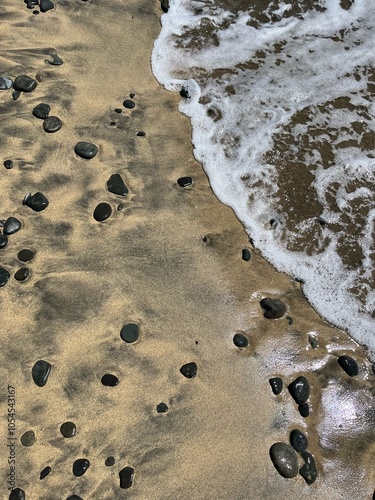 Sea water foam on the shore with sand and pebbles. Abstract seascape background wallpaper with copy space