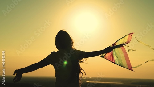 kite. colored rainbow kite hands girl with long hair. happy family. chidhood dream. girl park sunset playing with kite. child teenager journey. fantasy child. concept kite wind. play game nature. sun. photo