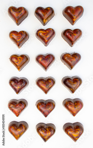 Chocolate bonbons arranged in rows and columns on a white background, hand-painted. Concept for Valentine's Day and Christmas gifts.