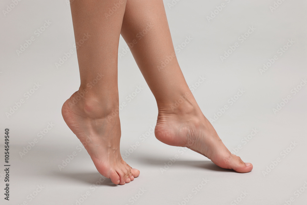 Woman with smooth feet on grey background, closeup Woman with smooth feet on grey background, closeup