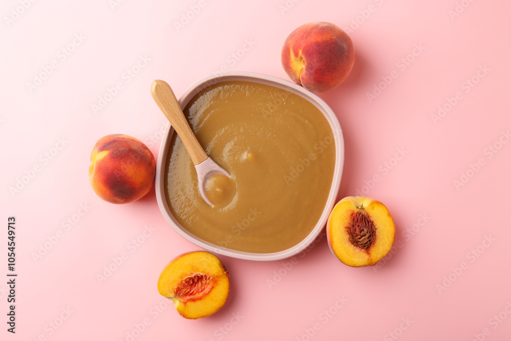 Delicious baby food with spoon in bowl and fresh peaches on pink table, flat lay Delicious baby food with spoon in bowl and fresh peaches on pink table, flat lay