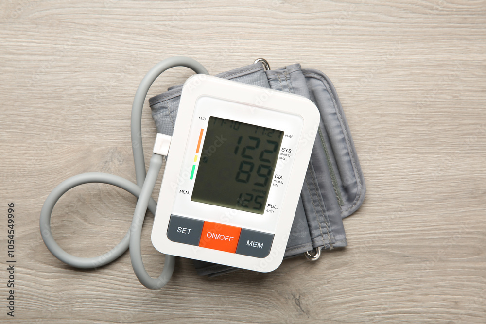 Blood pressure measuring device on wooden table, top view Blood pressure measuring device on wooden table, top view