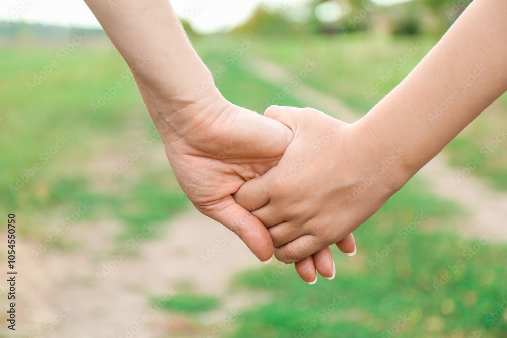 Mother and son holding hands outdoors, closeup Mother and son holding hands outdoors, closeup