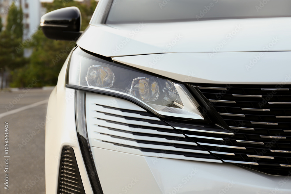 Closeup view of modern white car parked outdoors Closeup view of modern white car parked outdoors