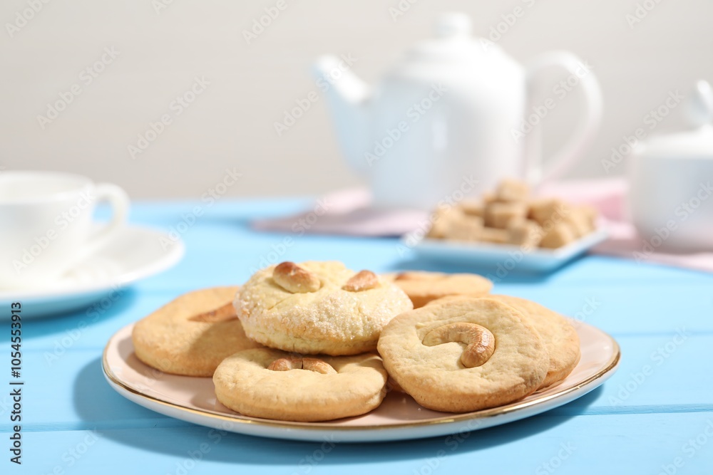 Plate with tasty cashew cookies on light blue wooden table, closeup Plate with tasty cashew cookies on light blue wooden table, closeup