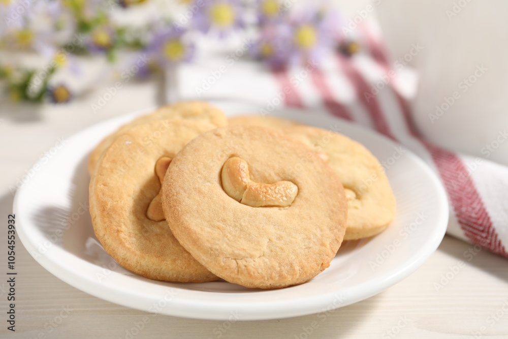 Plate with tasty cashew cookies on white wooden table, closeup Plate with tasty cashew cookies on white wooden table, closeup