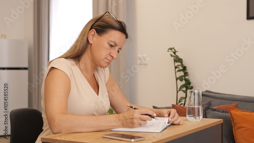Canvas Print Woman writing in notebook while working at her desk