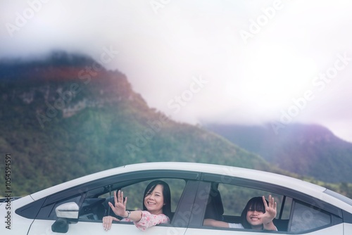 Schilderij op canvas Mother and daughter travel to the top of a mountain by car on a holiday trip