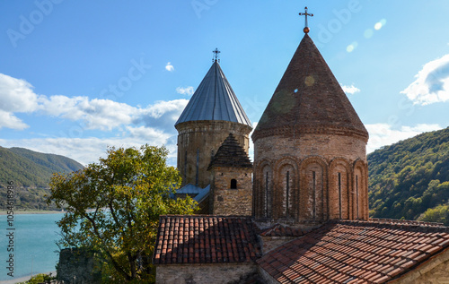 Majestic Ananuri Fortress with domes of two large churches, historic castle complex in Georgia, standing proudly against a backdrop of lush greenery and the serene waters of the Zhinvali Reservoir photo