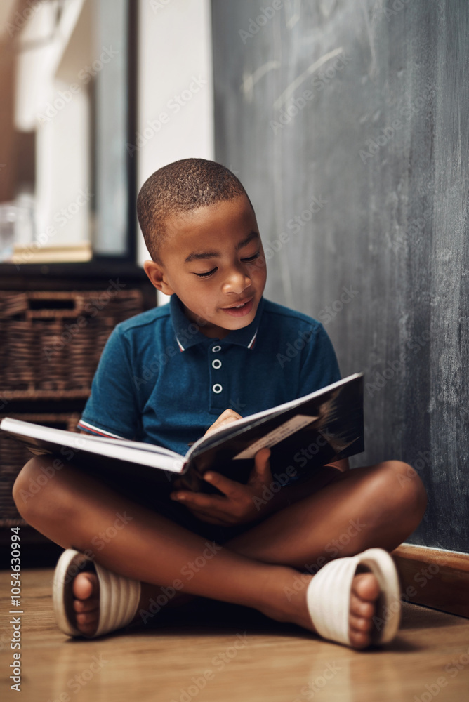 Boy, school and floor with book for reading, learning or education in literature or studying by blackboard. Young, male person or child with story for novel, imagination or fantasy in classroom Boy, school and floor with book for reading, learning or education in literature or studying by blackboard. Young, male person or child with story for novel, imagination or fantasy in classroom