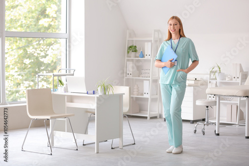 Happy female doctor with clipboard and badge in clinic