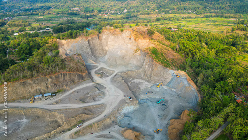 In this striking landscape, heavy machinery dominates as it excavates the mountainside, revealing hidden treasures within. Dust clouds rise from the intense operation, showcasing the powerful intersec