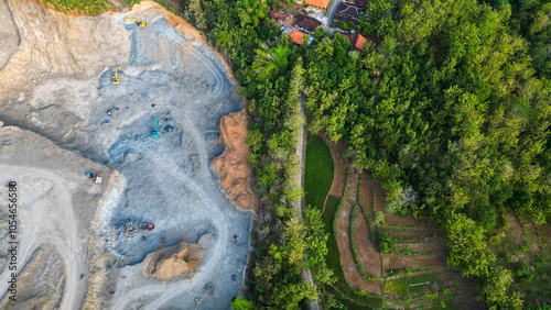 In this striking landscape, heavy machinery dominates as it excavates the mountainside, revealing hidden treasures within. Dust clouds rise from the intense operation, showcasing the powerful intersec