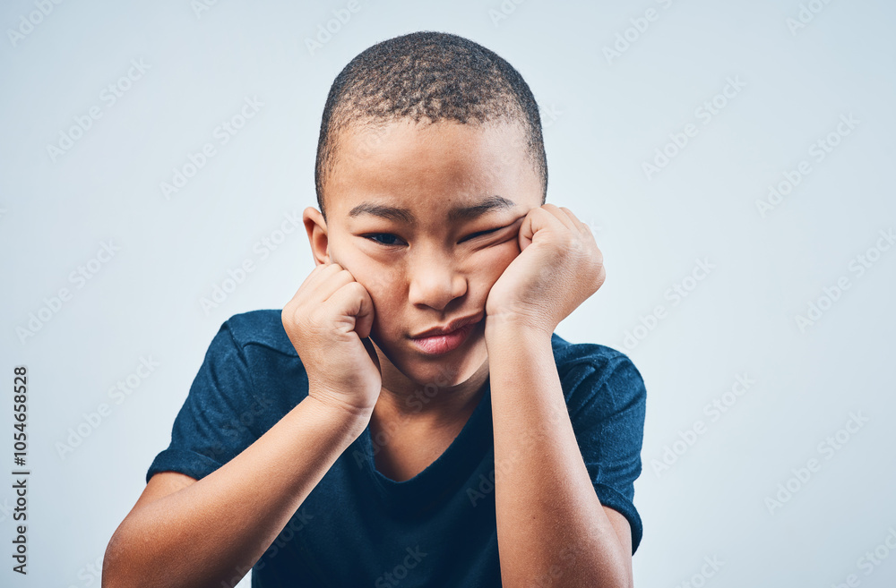 Portrait, boredom and sad with boy, kid or facial expression on gray studio background. Face, childhood or model with emotion, reaction or depression with mental health, fatigue or tired with burnout Portrait, boredom and sad with boy, kid or facial expression on gray studio background. Face, childhood or model with emotion, reaction or depression with mental health, fatigue or tired with burnout