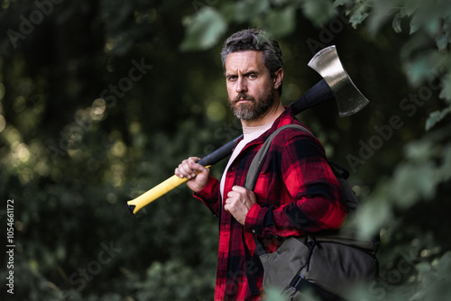 Men power. Muscular sexy Lumberjack. Logging and chopping concept. Lumberjack worker in the forest. Lumberjack in the woods with axe. Brutal bearded lumberjack with ax. photo