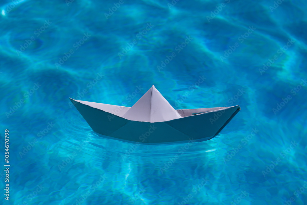 Paper boat on the sea background. Origami paper boat sailing on water causing waves and ripples. Paper boat on the sea background. Origami paper boat sailing on water causing waves and ripples.