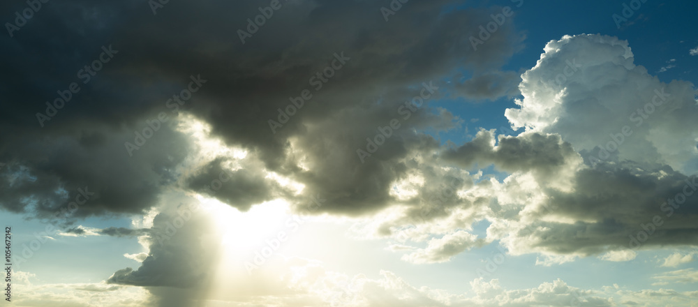 Fototapeta premium Beautiful sunset sky with clouds. Sky blue and orange light of the sun through the clouds in sky. Background of dark clouds before storm. Dramatic clouds. Apocalyptic sky, dark cloud.