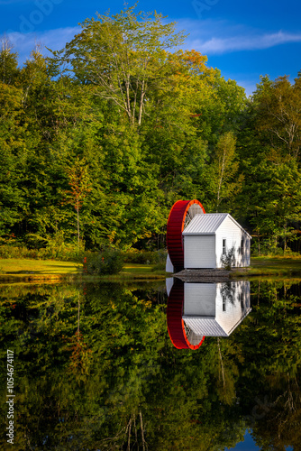 Serene Watermill Reflection by a Forested Lake
