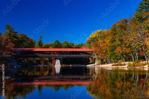 Historic Red Covered Bridge Surrounded by Vibrant Fall Foliage