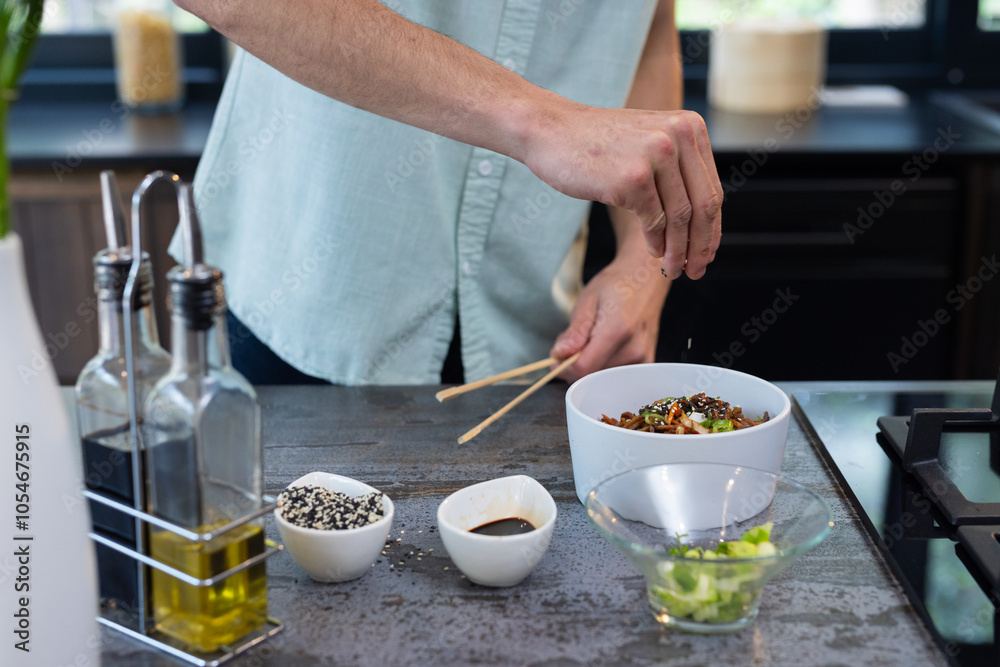 man seasoning homemade dish in modern kitchen with fresh ingredients man seasoning homemade dish in modern kitchen with fresh ingredients