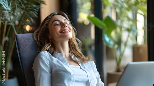 Glad business lady relaxing on chair front of laptop in office, work break.