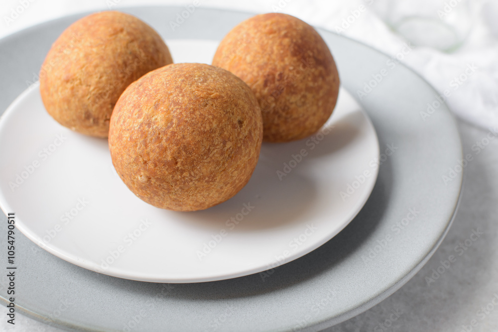homemade nigerian egg roll in a white ceramic plate, freshly made african egg roll on a white plate, egg wrapped in fried dough homemade nigerian egg roll in a white ceramic plate, freshly made african egg roll on a white plate, egg wrapped in fried dough