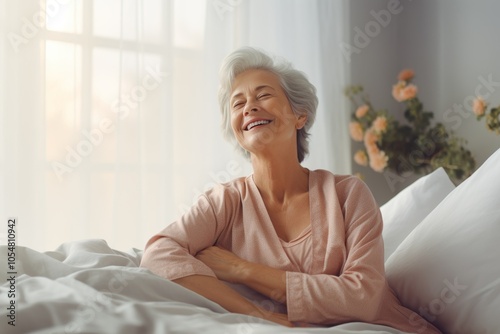 Mature woman joyfully stretching in bed at dawn, enjoying tranquility and a new day in a beautifully lit bedroom