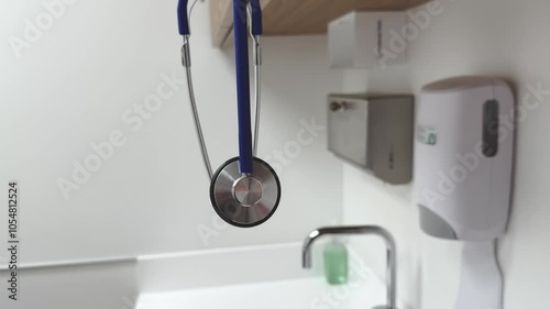 Close up of a blue stethoscope hanging in medical examination room.