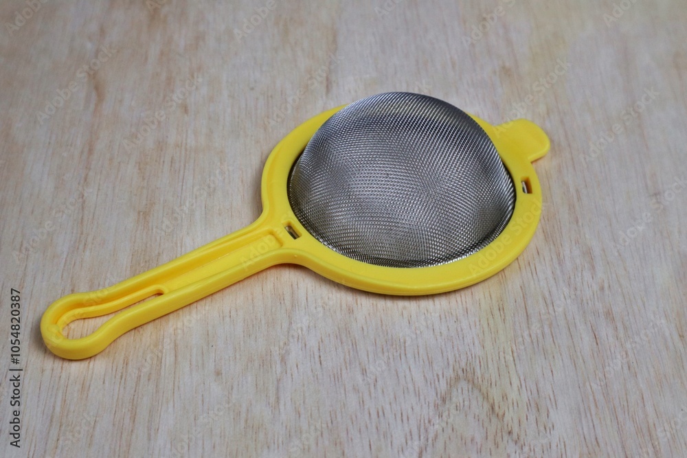 close up view of tea strainer wooden background