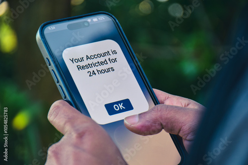 Man got his social media account restricted message on his mobile phone. Selective focus.