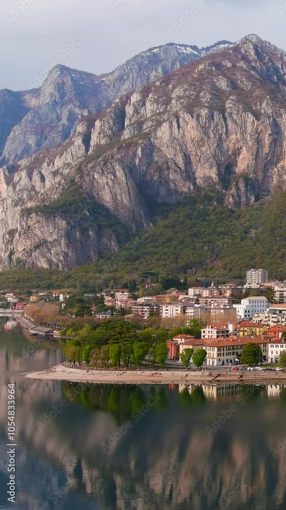 Aerial beautiful sunset cityscape of Lecco town and resort. Picturesque waterfront of Lecco town located between famous Lake Como and scenic Bergamo Alps mountains. Vacation destination in Italy. Aerial beautiful sunset cityscape of Lecco town and resort. Picturesque waterfront of Lecco town located between famous Lake Como and scenic Bergamo Alps mountains. Vacation destination in Italy.