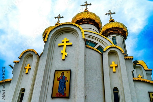 Close-up of an Orthodox church facade with golden domes and crosses under a bright blue sky The architectural details and vibrant colors highlight the beauty of this religious landmark in Byzantine st