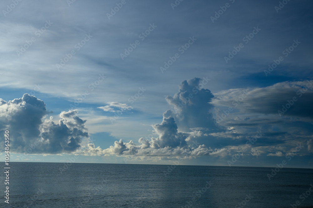 Blue sky with clouds over a calm ocean horizon Blue sky with clouds over a calm ocean horizon