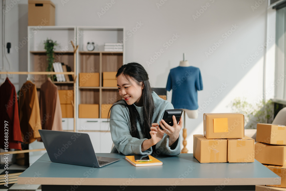 Successful fashion designer. Attractive woman with smile while standing in workshop. Beautiful owner woman working and holds tablet, laptop Successful fashion designer. Attractive woman with smile while standing in workshop. Beautiful owner woman working and holds tablet, laptop