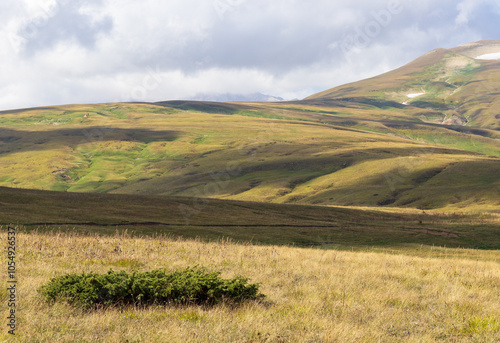 panorama of the mountainous area in the autumn period of the year, yellowed slopes, remnants of snow, dried plants