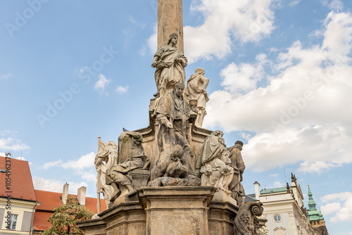 Group of sculptures at bottom part of Marian Plague Column in garden on Hradcanska Square in Prague in Czech Republic