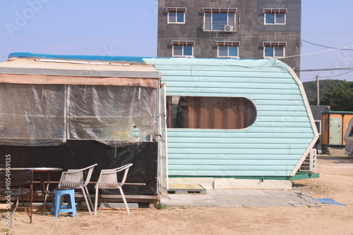 Light green beach camping trailer with chairs