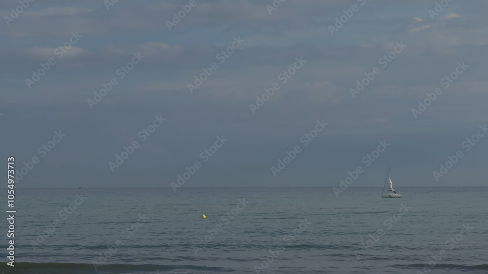Obraz premium Slow-motion sailing of yacht near beach buoy