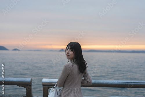 夕暮れの海にいる女性