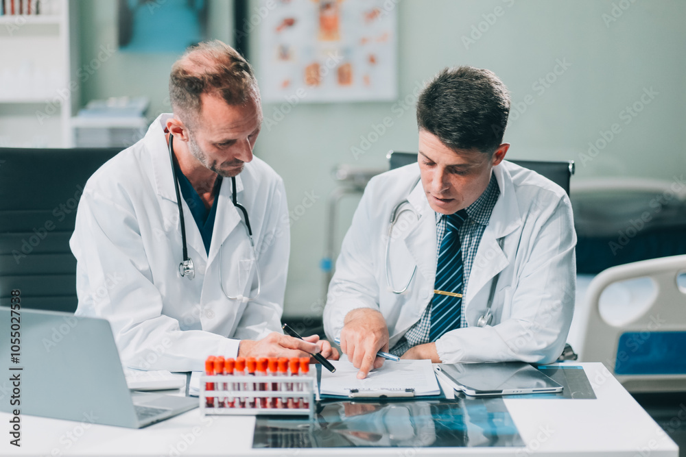 Fototapeta premium Group of medical practitioners working together and analyzing medical scan in the hospital
