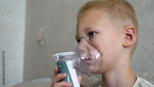Obraz na płótnie A young boy undergoes inhalation therapy at home to prevent asthma complications and colds